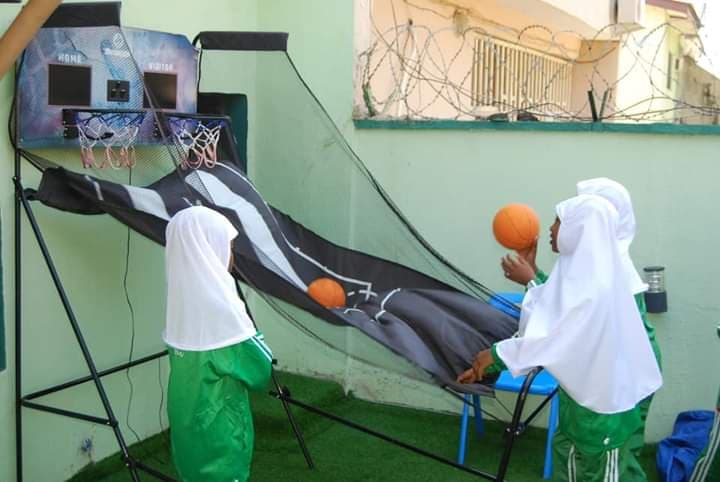 Two girls playing an arcade basketball game