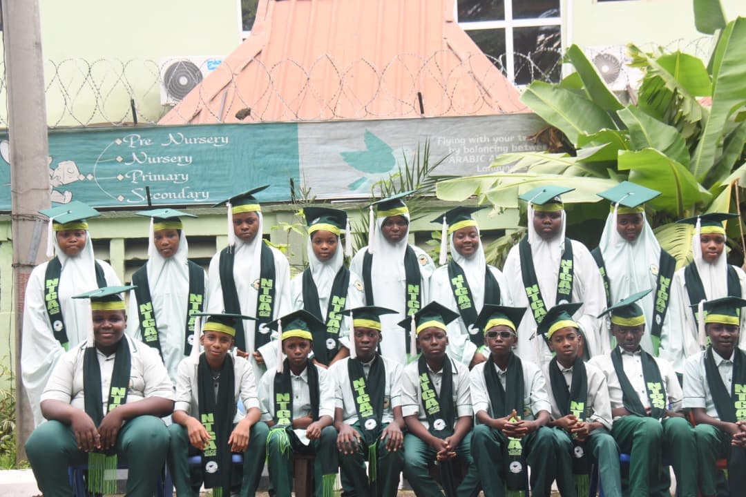 Full graduating class of NTGA students seated outside the school